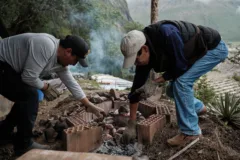 A traditional Peruvian meal being cooked with hot stones and fire.