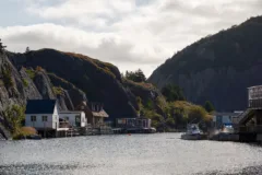 A small fishing harbour with colourful wooden buildings on stilts.