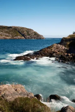 Rocky shoreline with waves gently lapping the rocks.