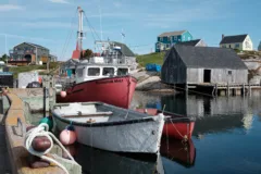 Fishing boats are tied to a dock in a small fishing harbour.