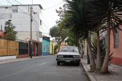 An old car parked on a colourful street in Barranco, Lima.