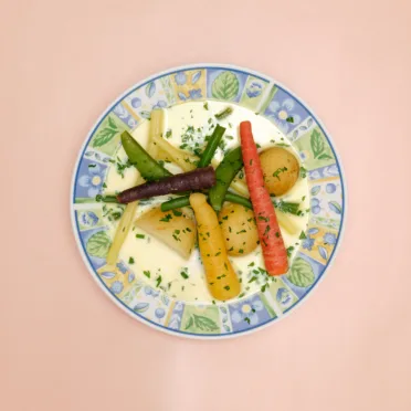 A bowl of Nova Scotian Hodge Podge on a pink background.