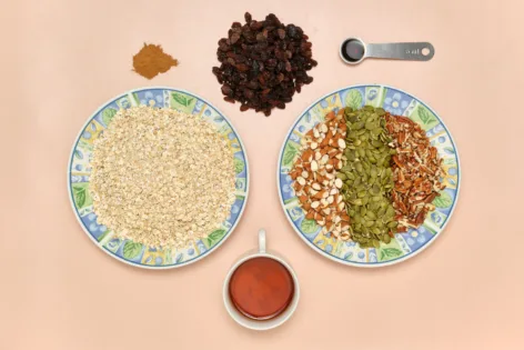 Ingredients needed to make Maple Nut Granola on a pink background.