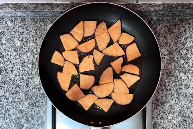 Slices of sweet potato in a frying pan.