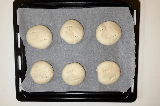 6 portions of dough on a baking tray.