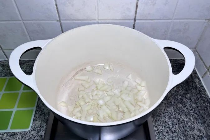 Onion frying in a large soup pan.