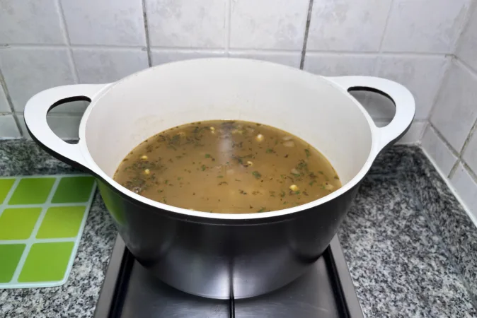 A bean stew simmering in a large soup pan.