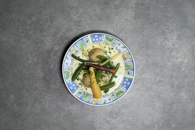 A bowl of Nova Scotian Hodge Podge sat on a grey kitchen counter.