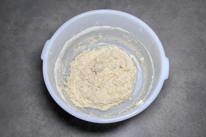 A white mixing bowl with dumpling dough inside.