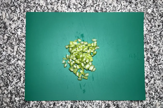 Diced celery on a green chopping board.