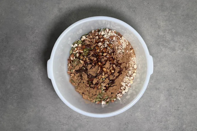 Ingredients for Maple Nut Granola in a large white bowl.