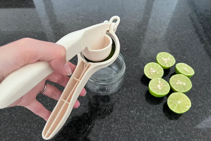 Limes being squeezed into a bowl using a hand held juicer.