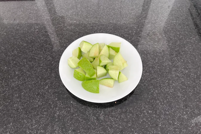 Small chunks of green apple on a white plate.