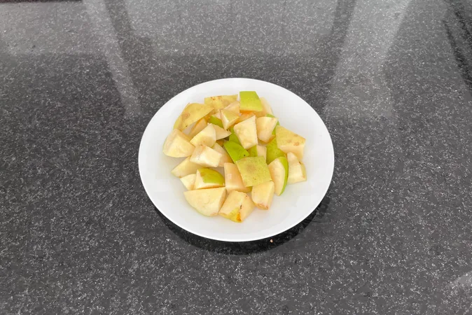 Small chunks of chopped quince on a white plate.